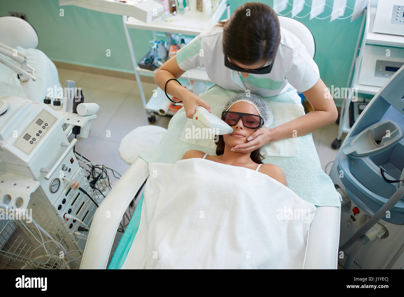 Laser hair removal in the beauty salon, woman having facial hair