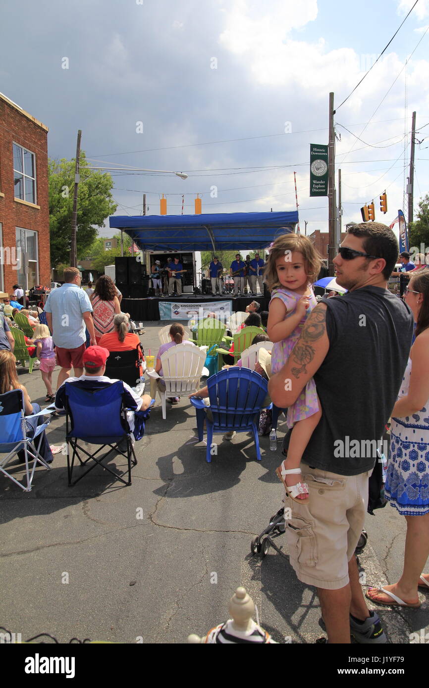 Young girl held by father enjoying dogwood festival in Mebane North