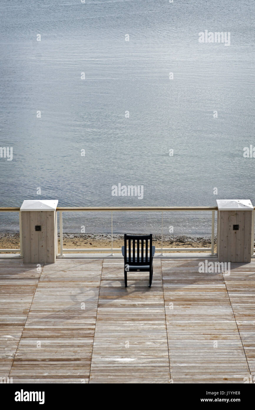 An empty chair near the ocean in Gloucester, Massachusetts. Stock Photo