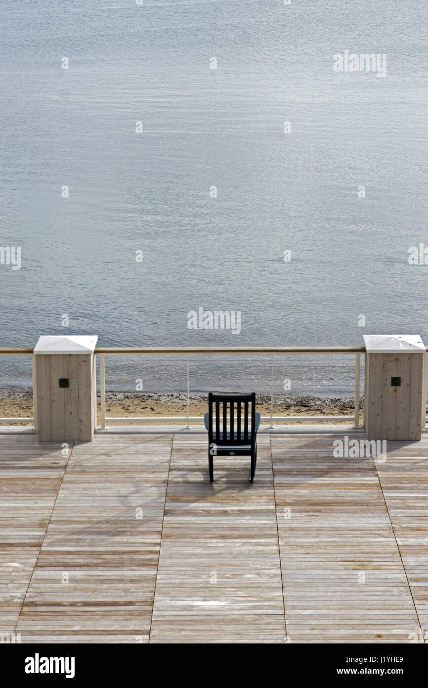An empty chair near the ocean in Gloucester, Massachusetts. Stock Photo