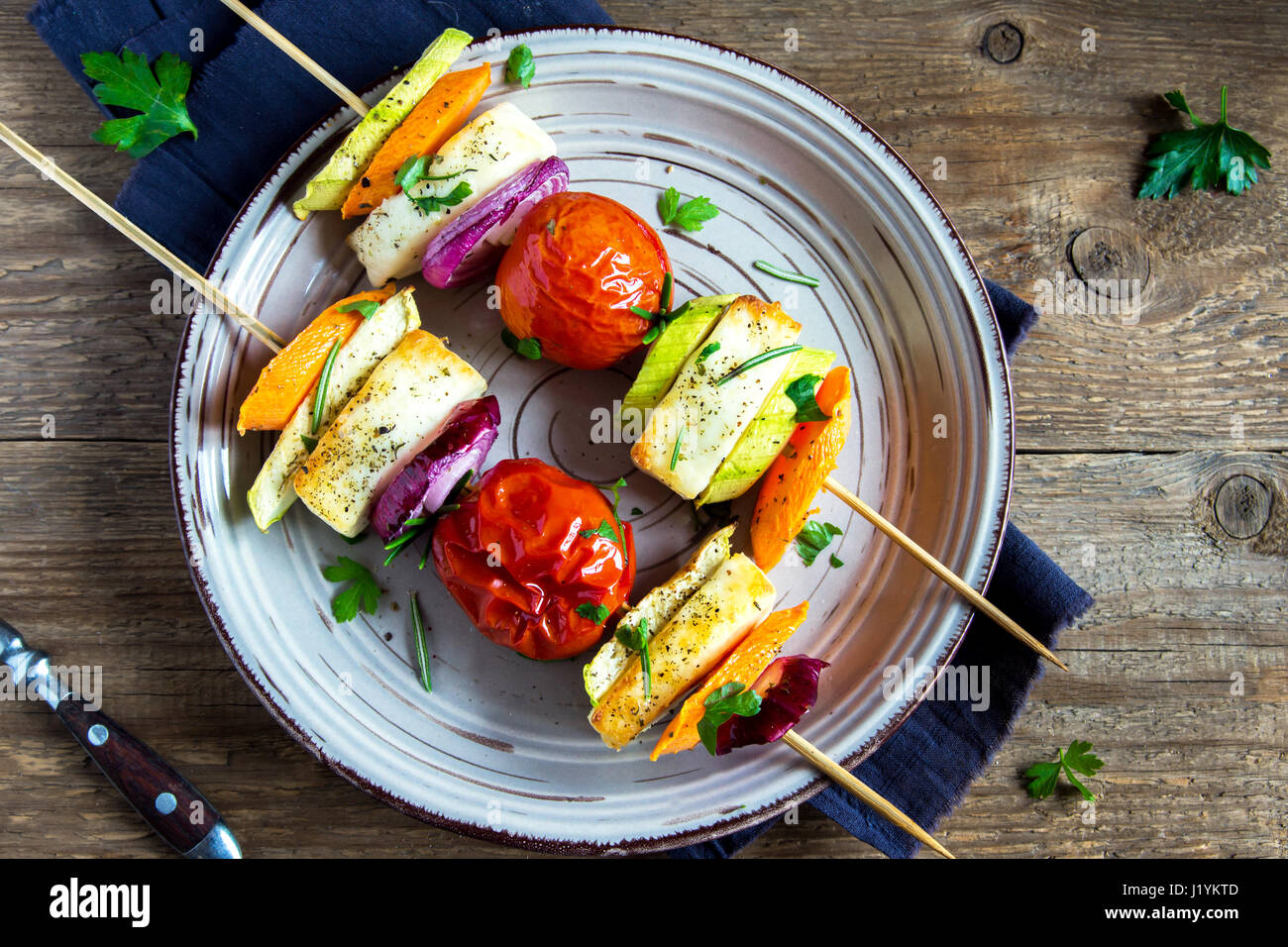 Halloumi cheese and vegetables grilled skewers on plate with spices and herbs close up healthy