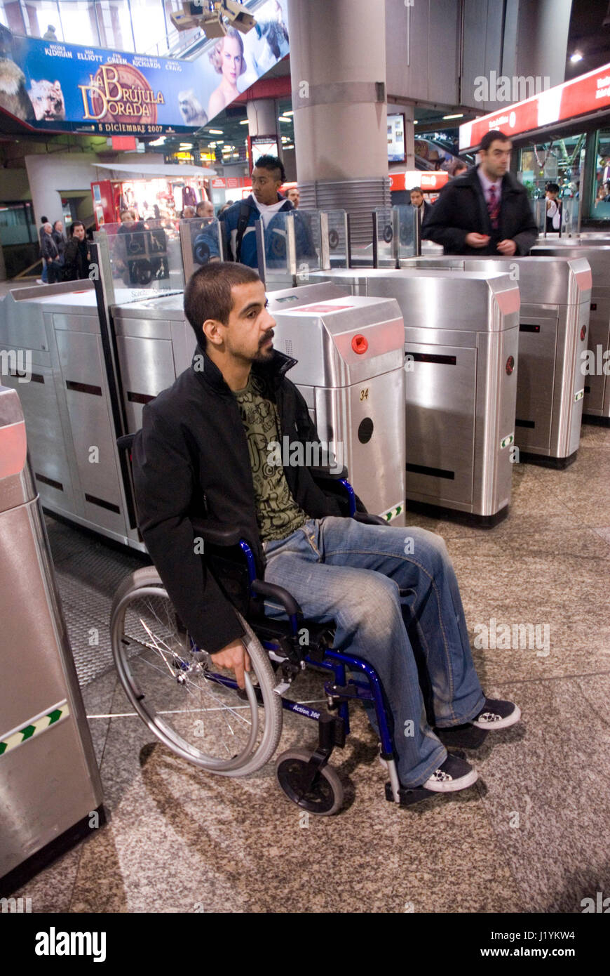 Young man on a wheelchair boarding suburban trains in Atocha Station