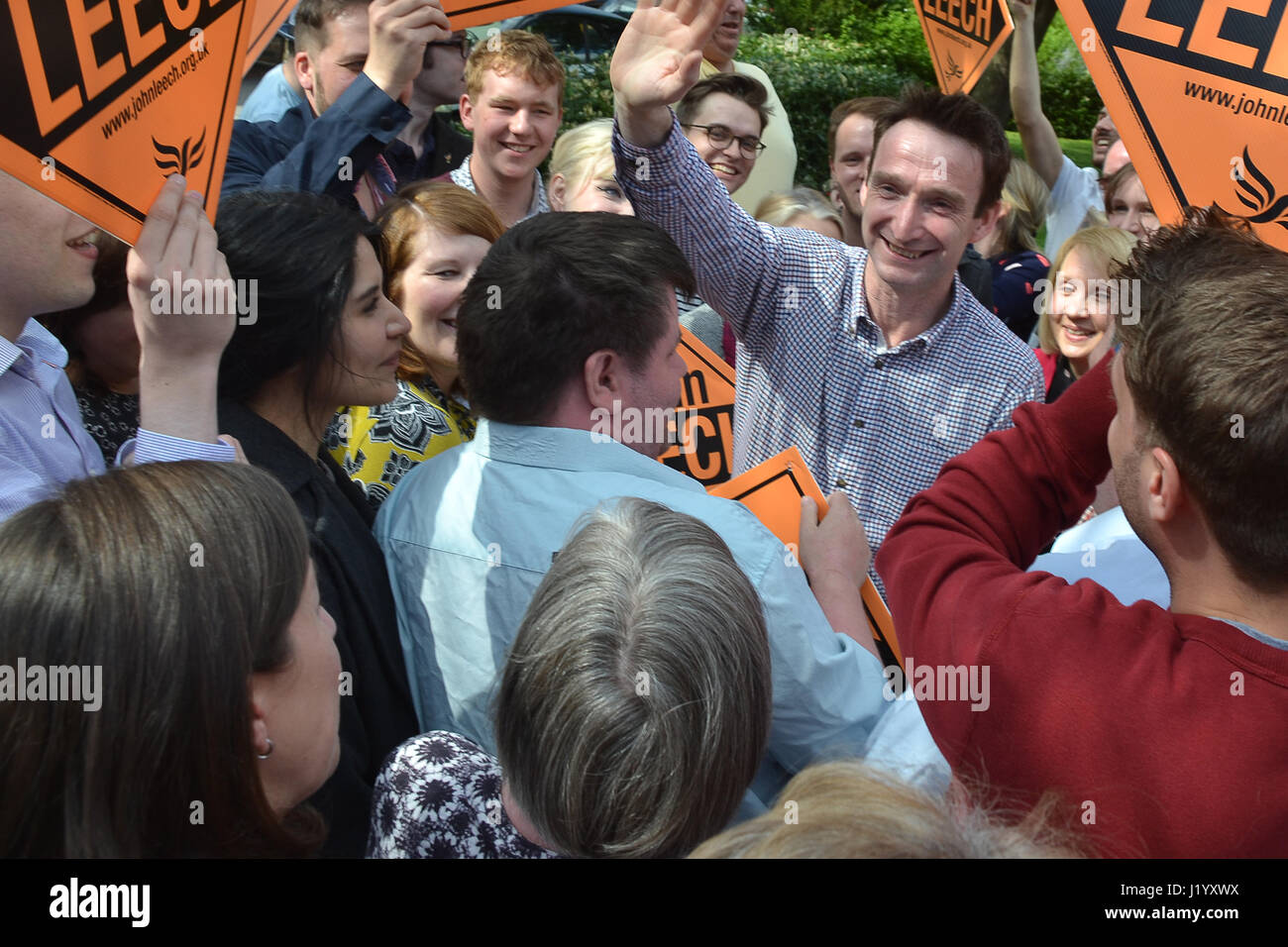 Didsbury, UK. 22nd April, 2017. John Leech is greeted and surrounded by crowds of supporters as he arrives in Didsbury to deliver his first campaign rally speech of the 2017 General Election. Leech was the Liberal Democrat MP for Manchester Withington from 2005 until 2015 when he lost to Labour. Leech was elected to Manchester Council in 2016 as the sole opposition, sweeping up 53% of the vote. He is hoping to regain the Withington Parliamentary seat in the 2017 general election. He promised to fight against a hard Brexit, saying Labour and Conservatives had let Manchester down over Brexit. Stock Photo