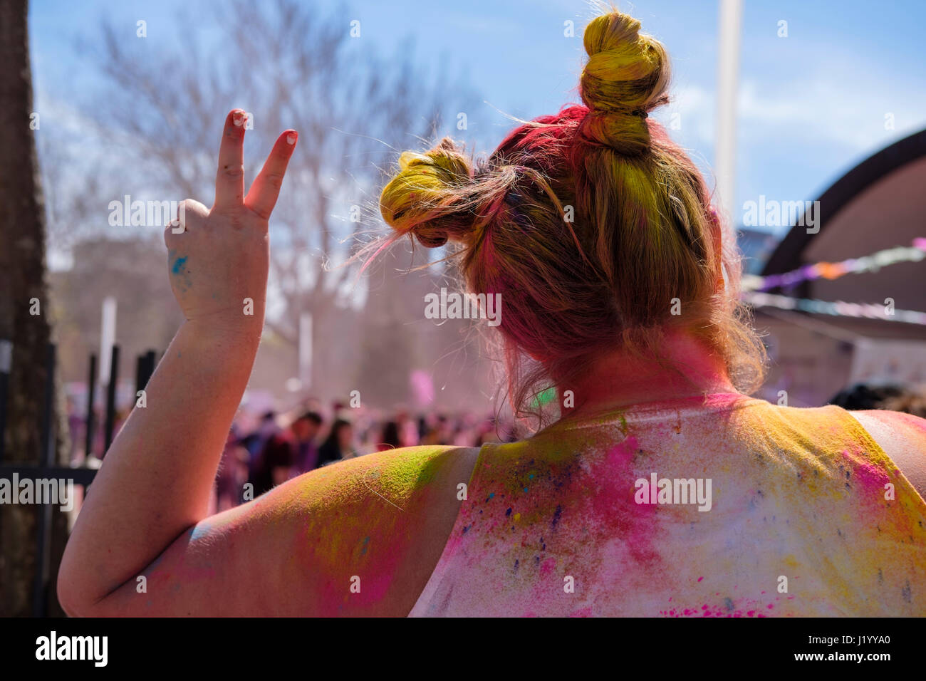 London, Ontario, Canada, 22nd Apr, 2017. Back of a young woman making the peace sign at Victoria Park during the Holi Spring Festival, also known as Rangwali Holi, Dhuleti, Dhulandi, Phagwah, or simply as Festival of Colours, an Hindu festival to celebrate the arrival of Spring in London, Ontario, Canada. Credit: Rubens Alarcon/Alamy Live News. Stock Photo