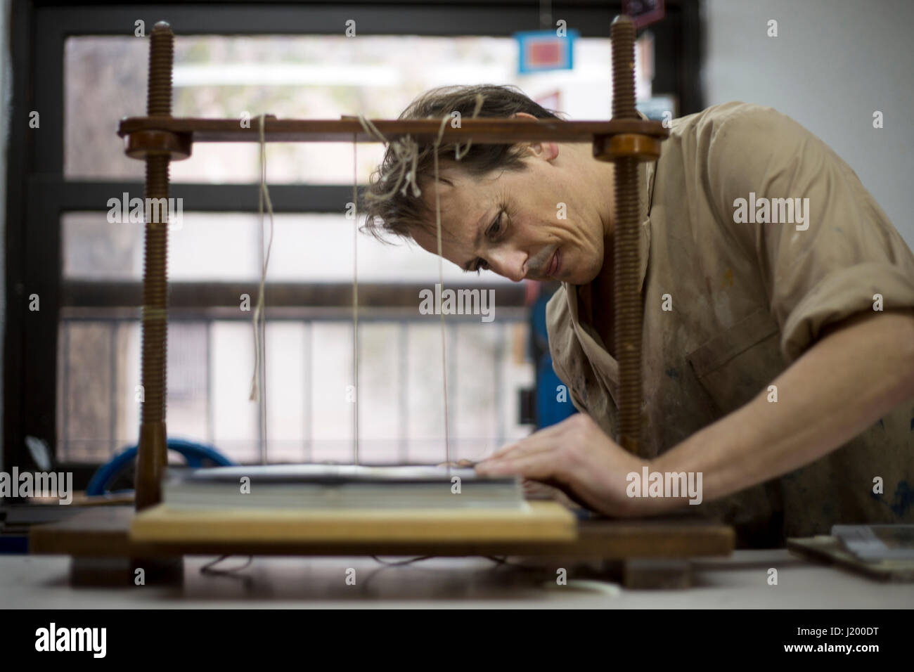 Florida, Argentina. 22nd Apr, 2017. Bookbinder Andres Casares sews the