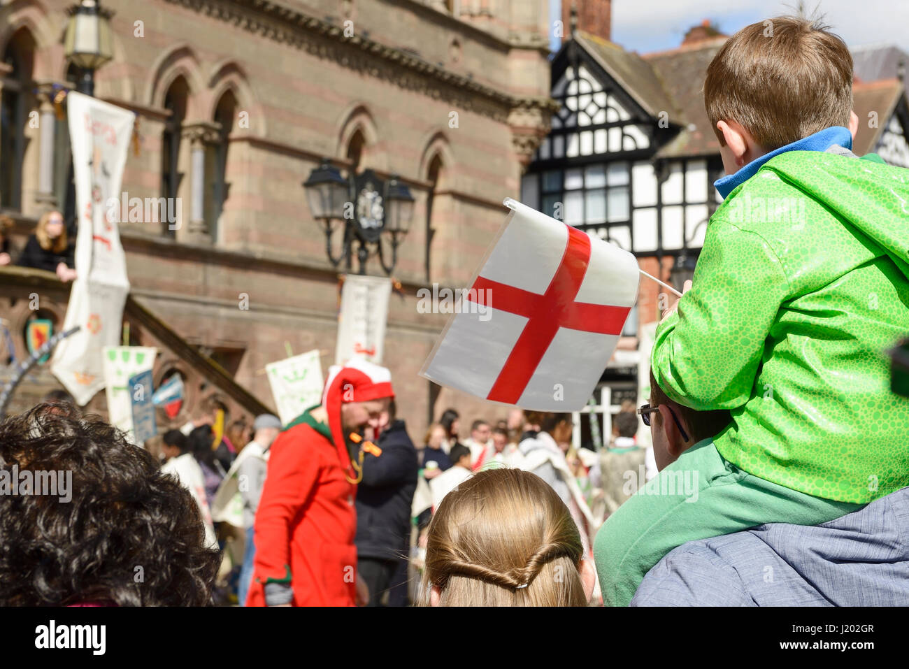 Chester, UK. 23rd April 2017. A boy with a flag watching the St George's day medieval street theatre performance in chester city centre. Credit: Andrew Paterson/Alamy Live News Stock Photo