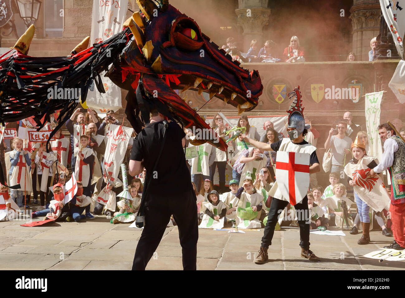 Chester, UK. 23rd April 2017. A smoke breathing dragon fights with St George as part of the St George's day medieval street theatre performance in Chester city centre. Credit: Andrew Paterson/Alamy Live News Stock Photo