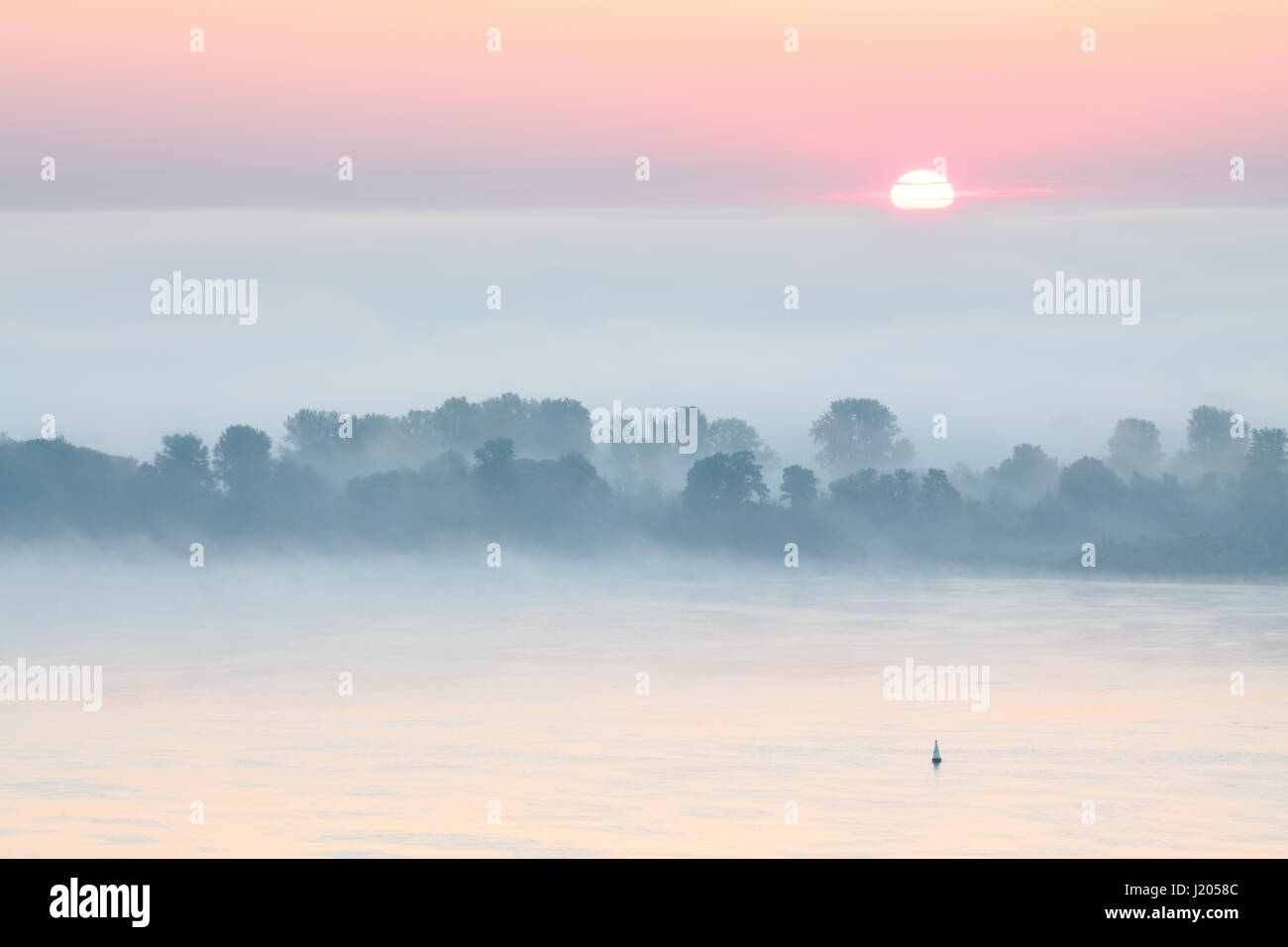 Extraordinary scenery of the river Volga covered with dense mist at sunrise Stock Photo