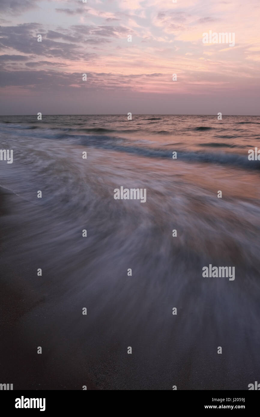 Beautiful seacoast scenery of the Azov Sea with a stunning view of the tides at sunrise Stock Photo