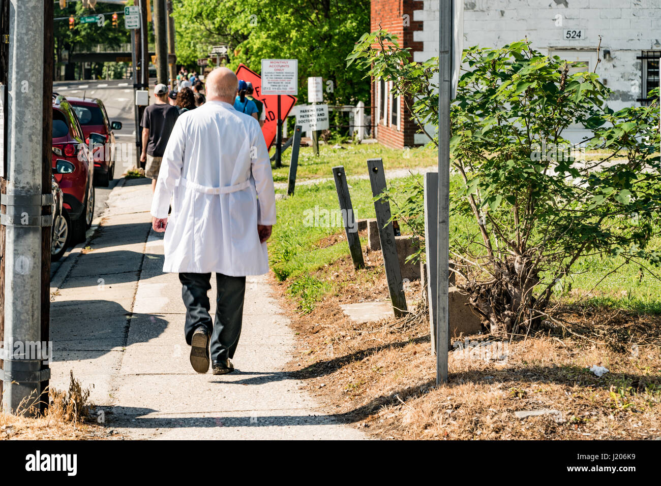 A doctor in a white coat walks through downtown Raleigh towards Shaw University for the 2017 March for Science. Stock Photo