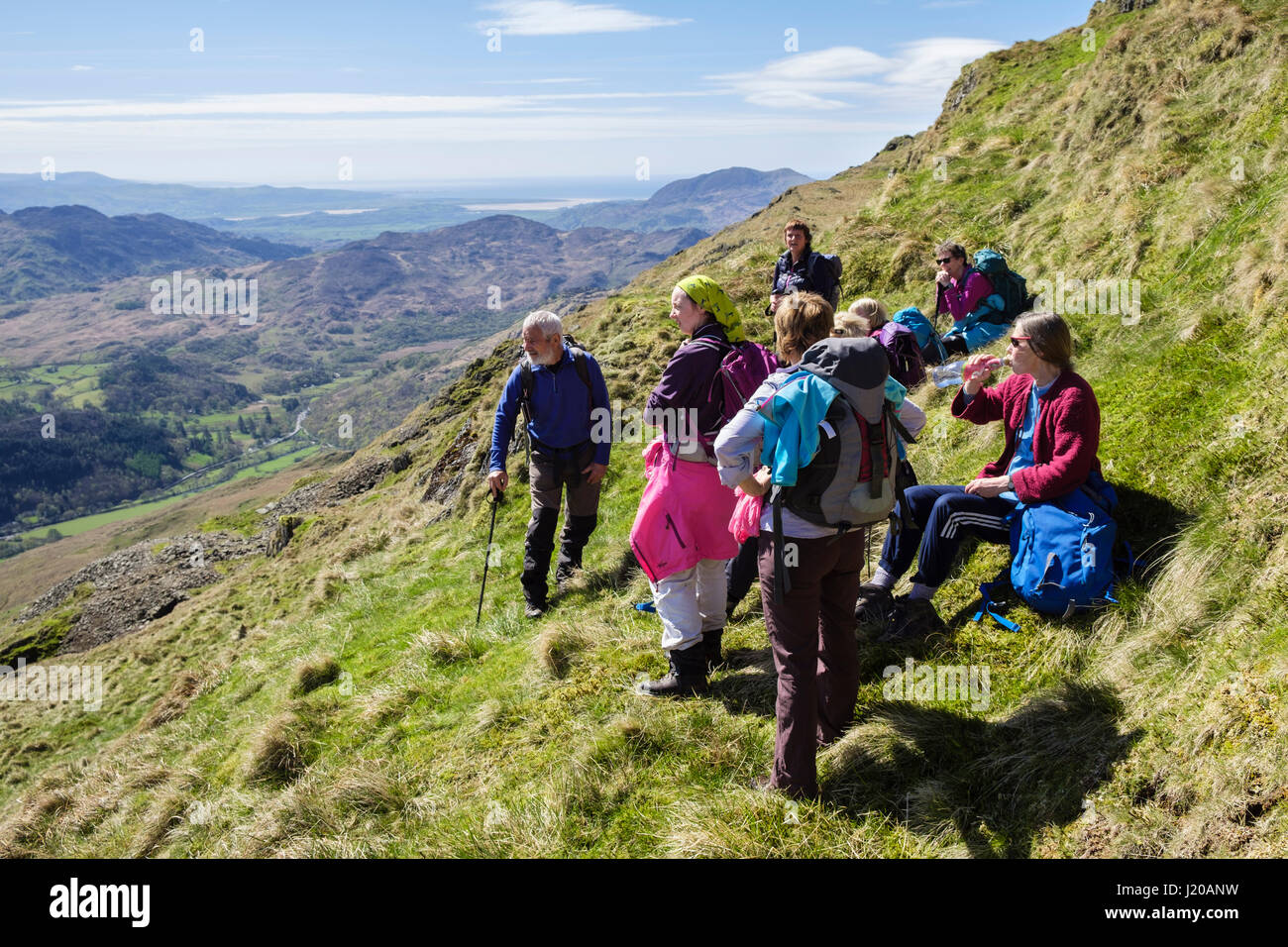 Hikers resting and looking at view on slopes of Y Lliwedd mountain in mountains of Snowdonia National Park. Gwynedd, Wales, UK, Britain Stock Photo