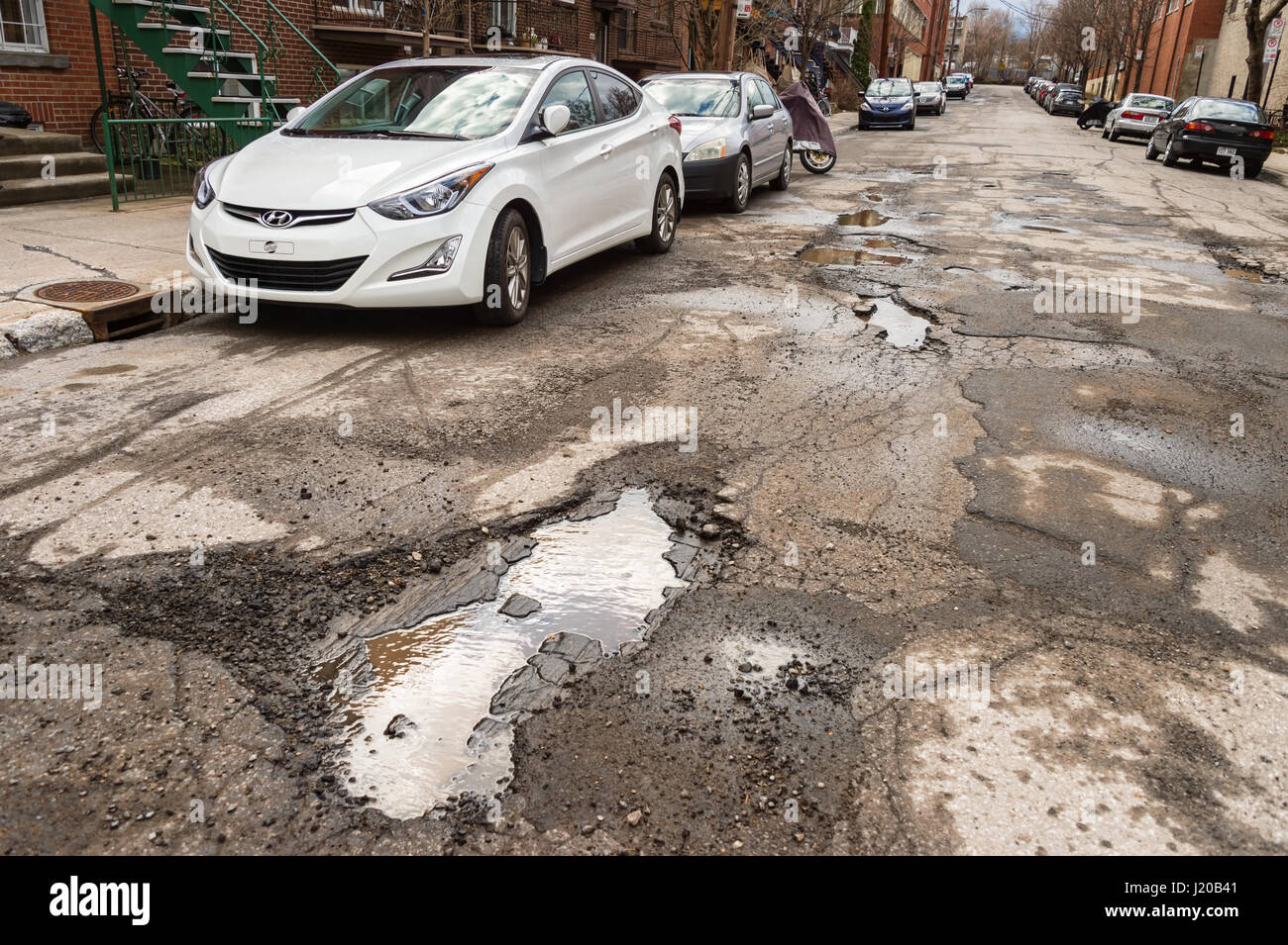 Montreal, Canada - 21 April 2017: Large unrepaired potholes on Chabot street Stock Photo