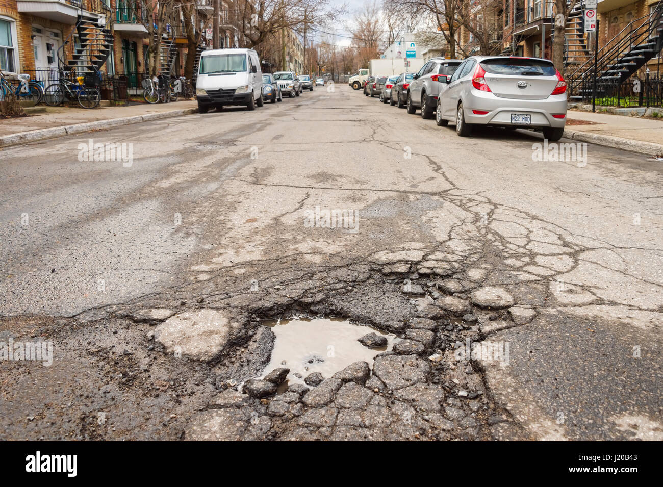 Montreal, Canada - 21 April 2017: Large unrepaired pothole on Cartier street Stock Photo
