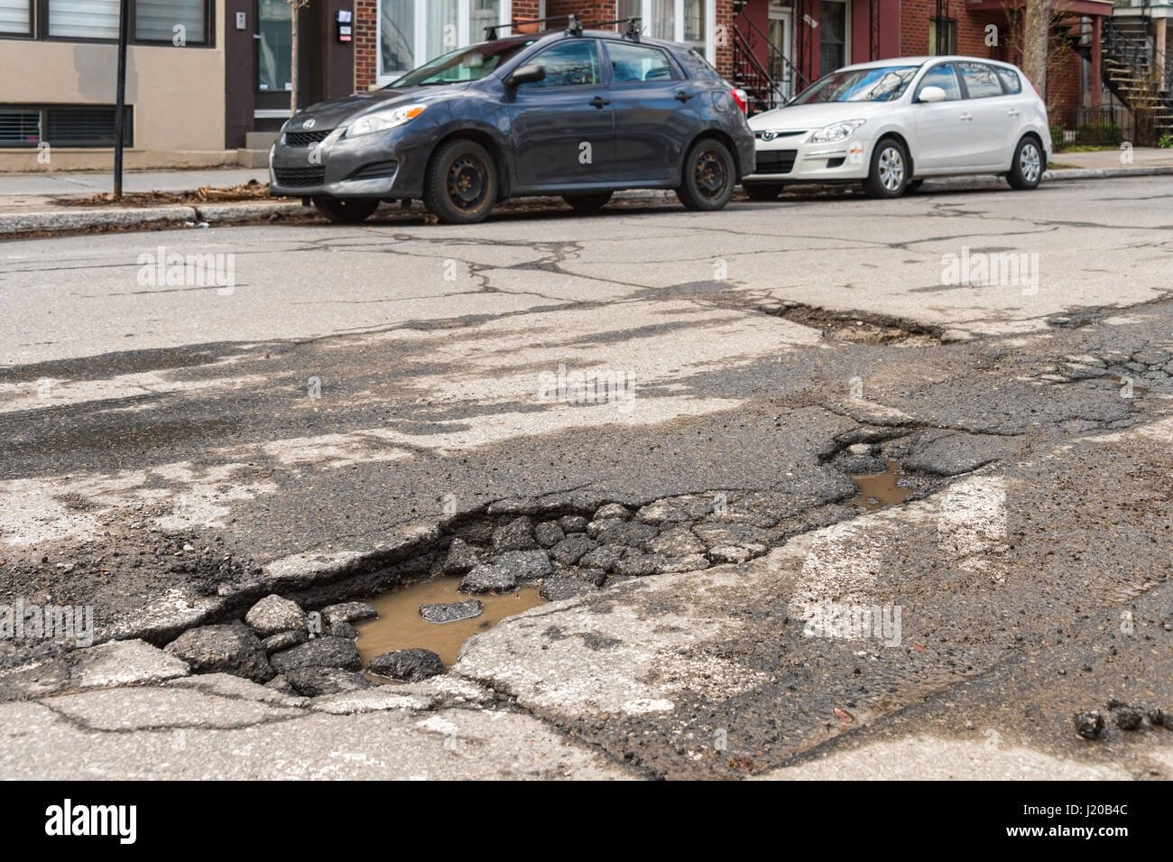 Montreal, Canada - 21 April 2017: Large unrepaired pothole on Gilford street Stock Photo