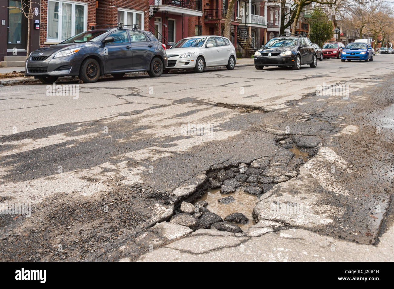 Montreal, Canada - 21 April 2017: Large unrepaired pothole on Gilford street Stock Photo