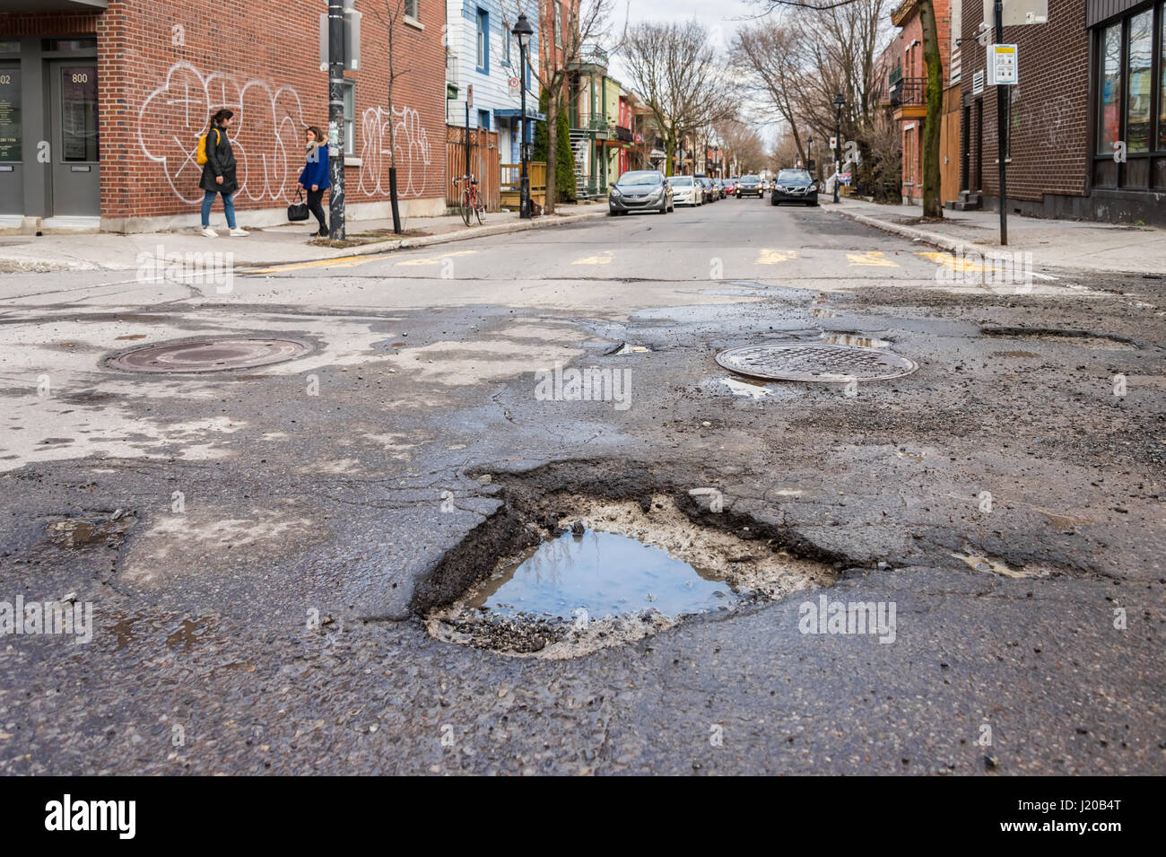 Montreal, Canada - 21 April 2017: Large unrepaired potholes on Gilford street Stock Photo