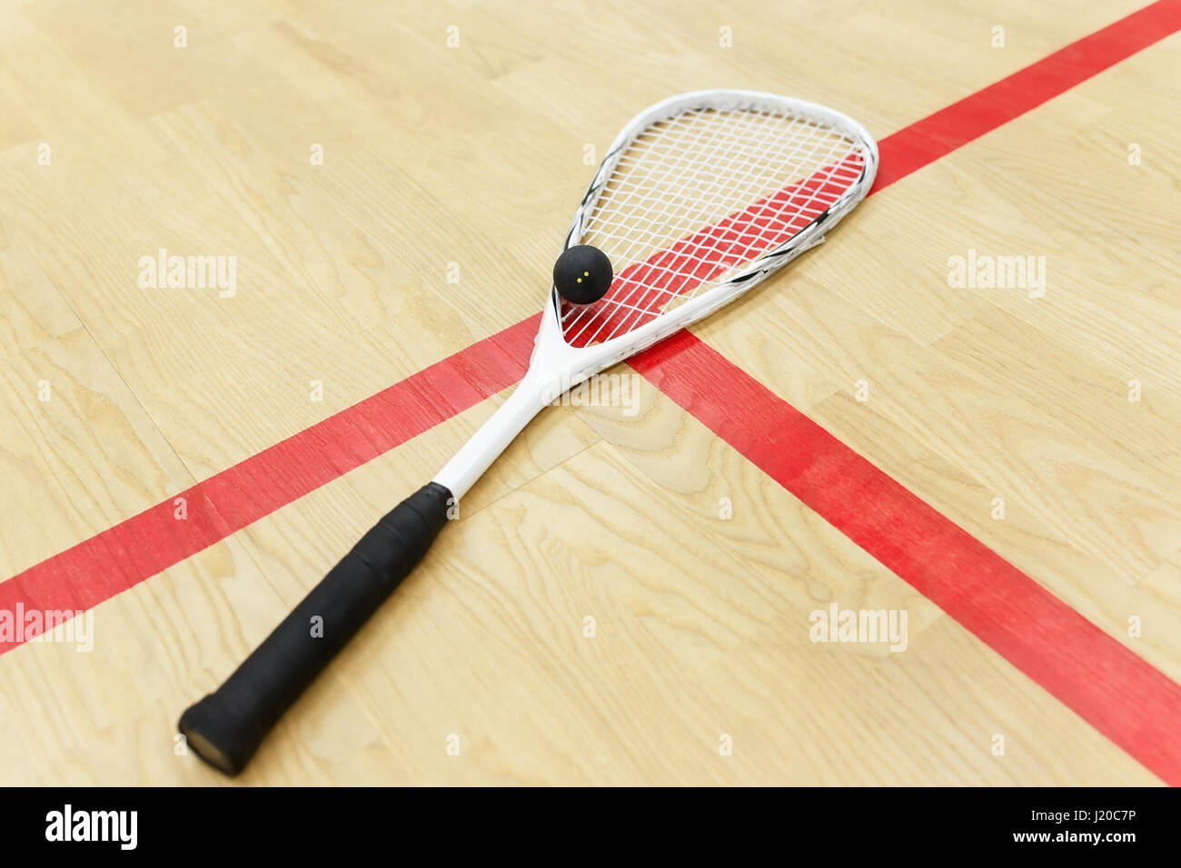 white squash racket and ball on the wooden background. Racquetball