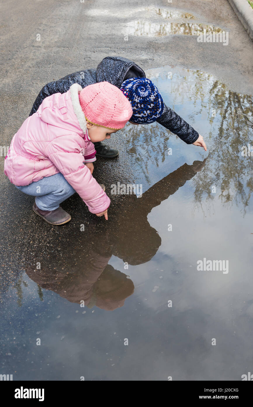 Girls playing in a puddle Stock Photo