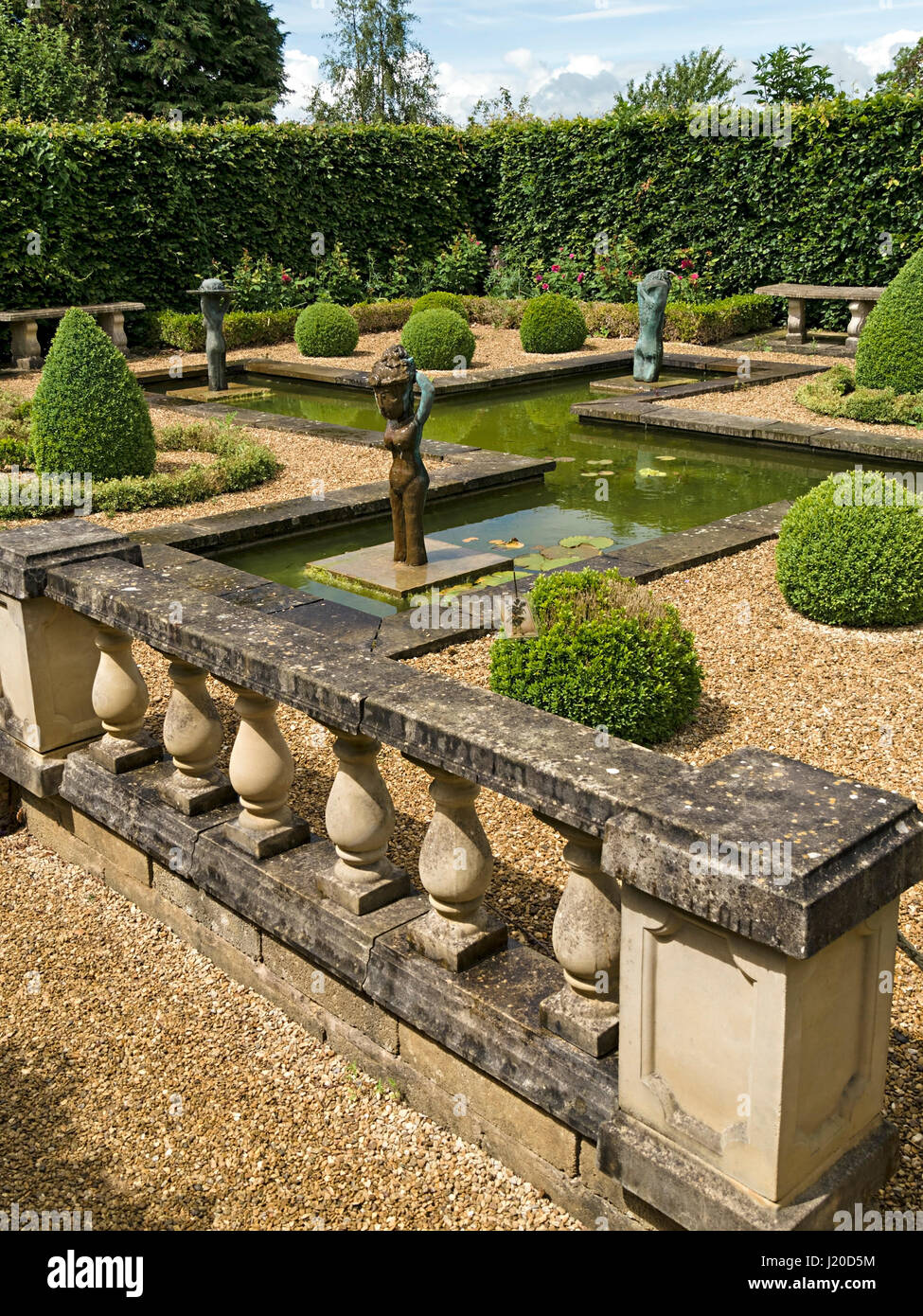 Small, formal, landscaped water garden, with sculptures by Lily Sawtell. Barnsdale Gardens, Rutland, England, UK. Stock Photo