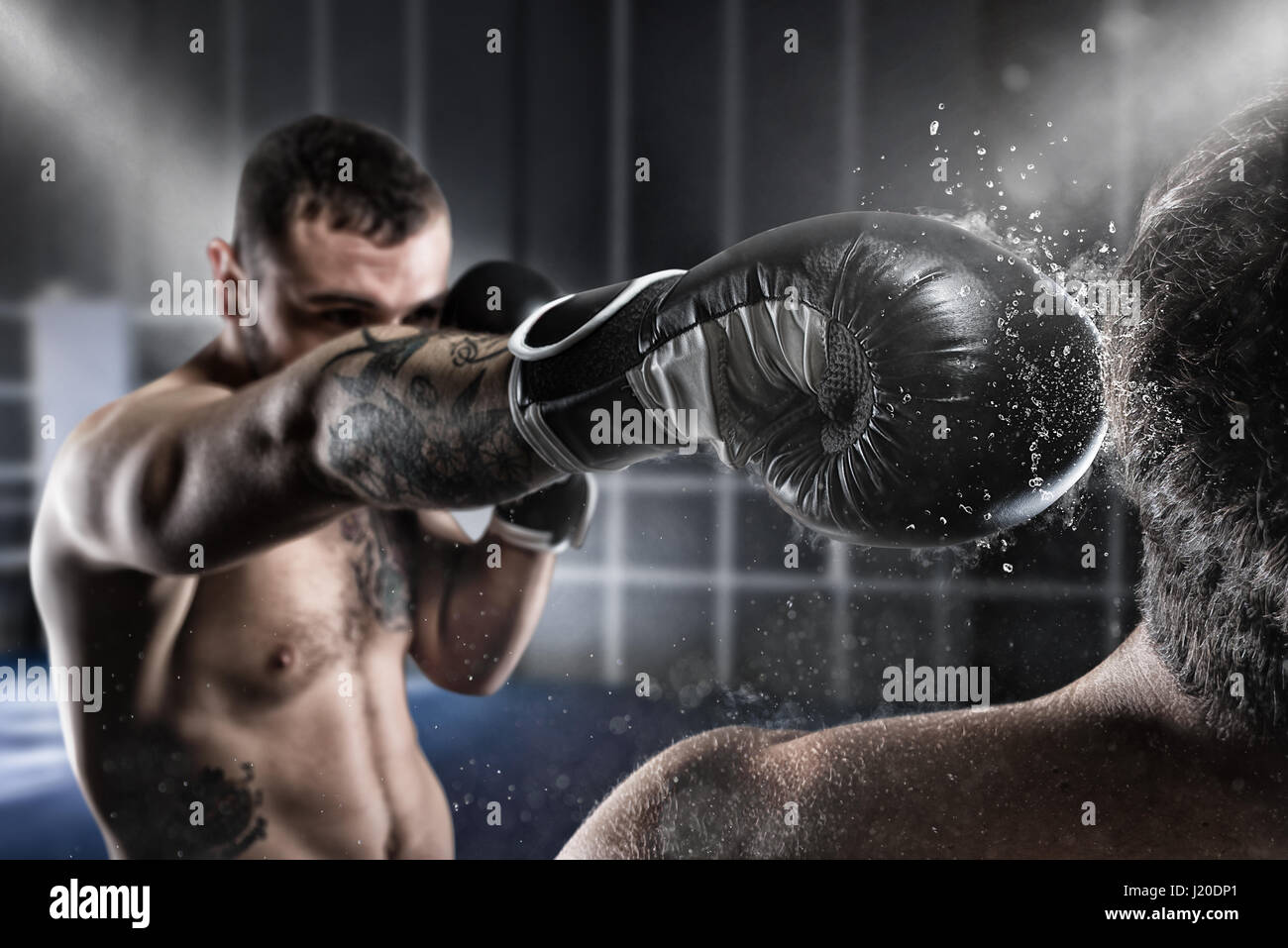 Boxer in a boxe competition beats his opponent Stock Photo