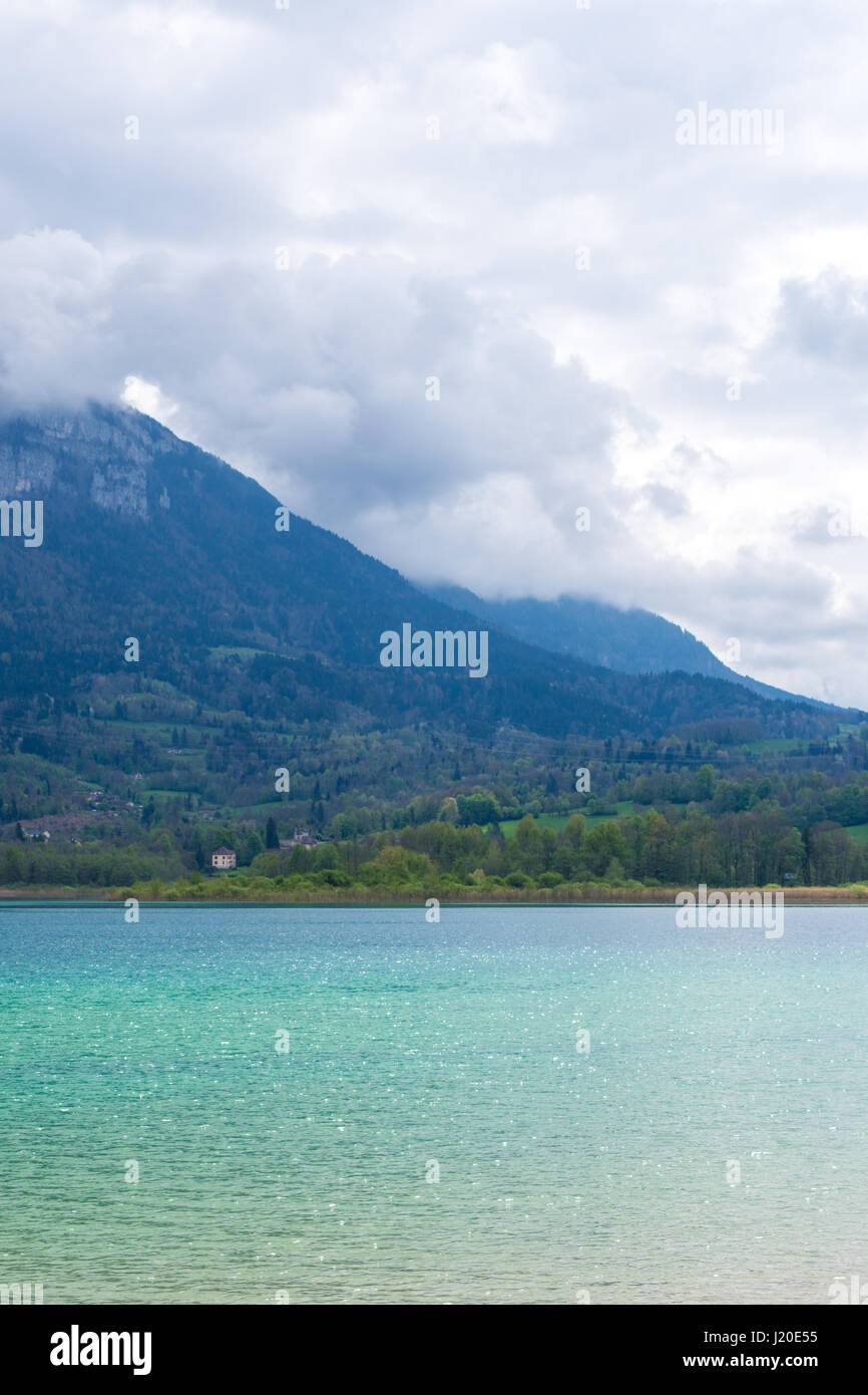 Lake Aiguebelette in France with mountains and clouds Stock Photo