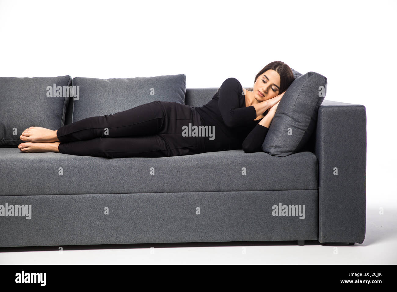Woman resting her head on a pillow in a couch Stock Photo Alamy