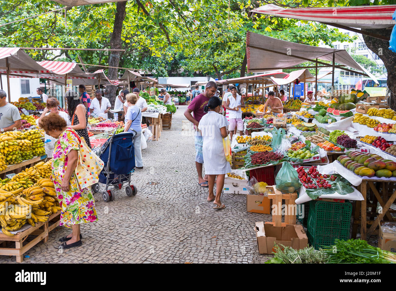 RIO DE JANEIRO - JANUARY 31, 2017: Customers browse the colorful fruit stalls of the weekly farmers market at General Osorio Plaza in Ipanema. Stock Photo