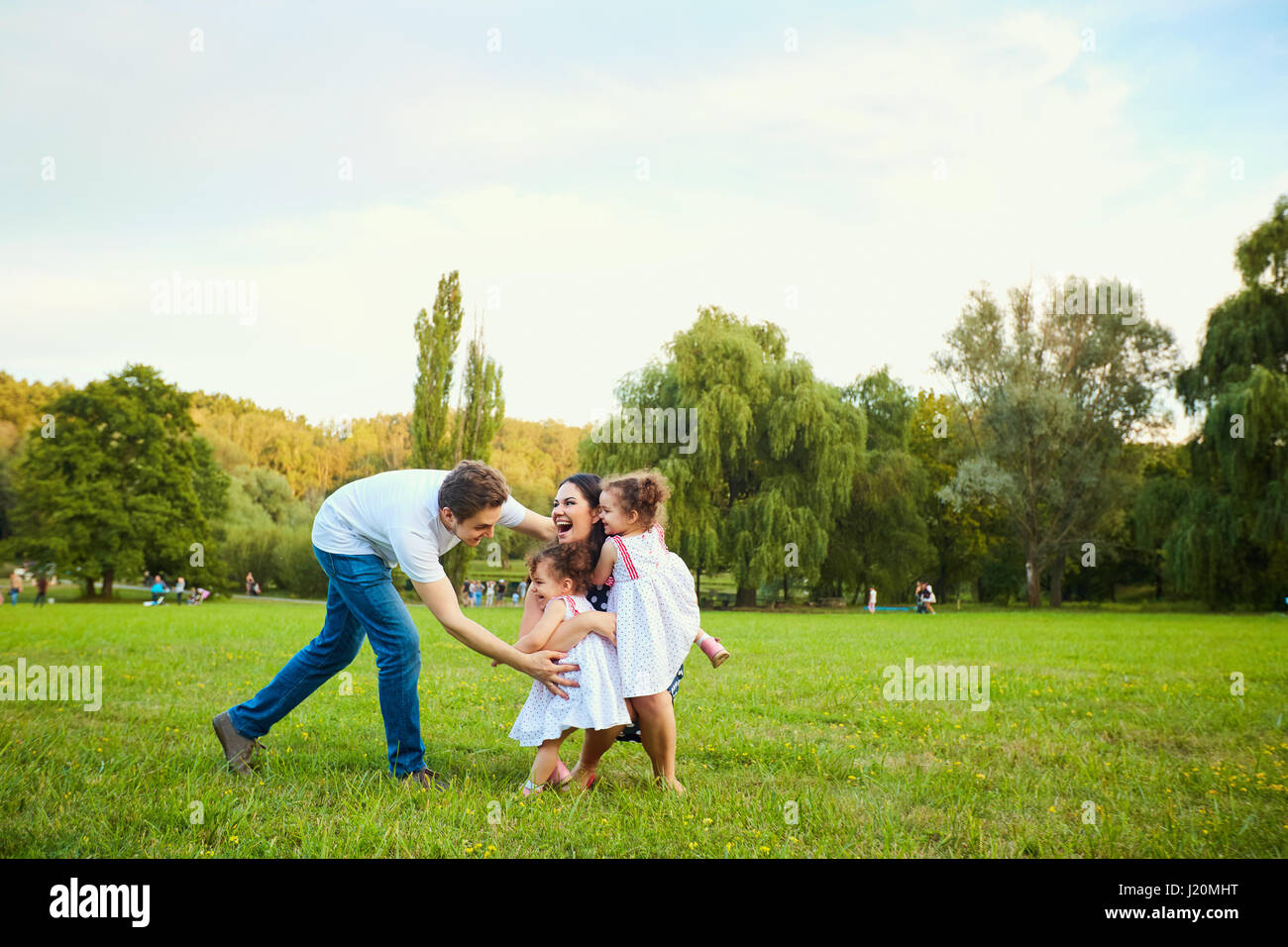 Happy family playing with children in the park Stock Photo - Alamy
