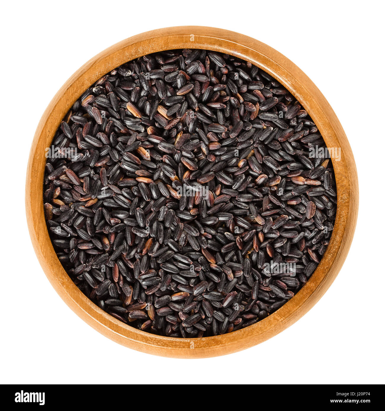 Organic black rice in wooden bowl. Also known as purple rice or pearl black. Oryza sativa. Rare Chinese rice, highest in protein. Stock Photo