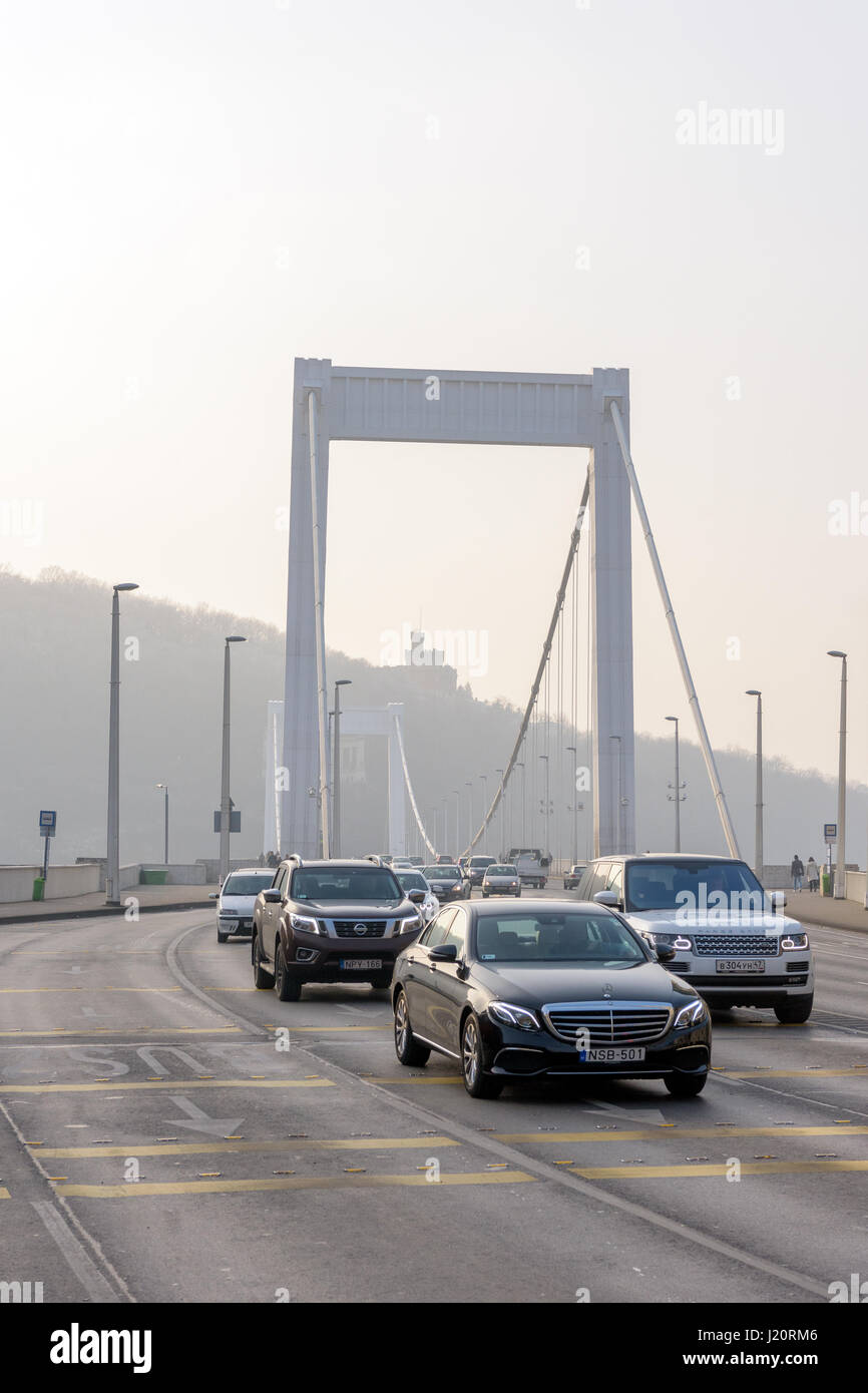 Luxury cars and Elizabeth bridge over Danube river in Budapest, Hungary during a foggy day Stock Photo