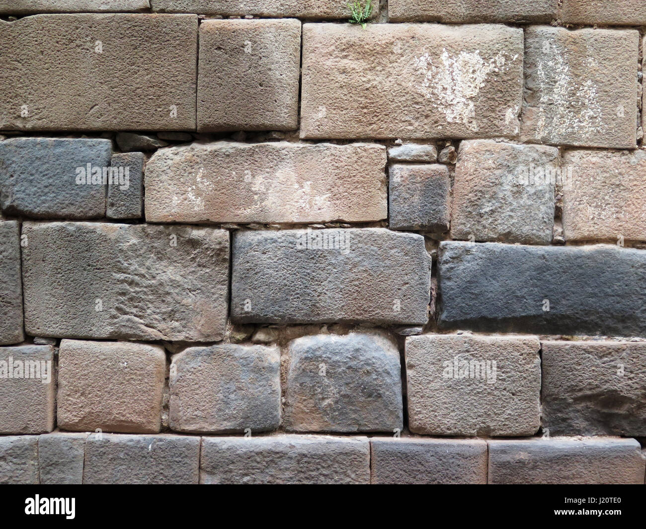 Inca wall made of natural volcanic stones, perfectly shaped, heritage of Inca history and architecture in Cusco, Peru. Stock Photo