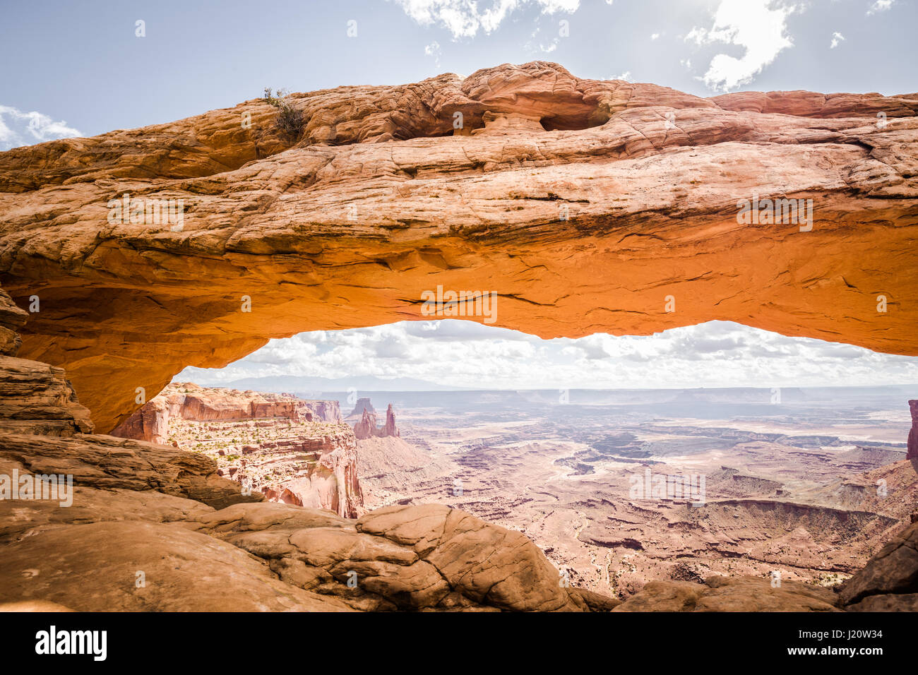 Classic view of famous Mesa Arch, symbol of the American Southwest, illuminated in scenic golden morning light at sunrise on a beautiful day in summer Stock Photo