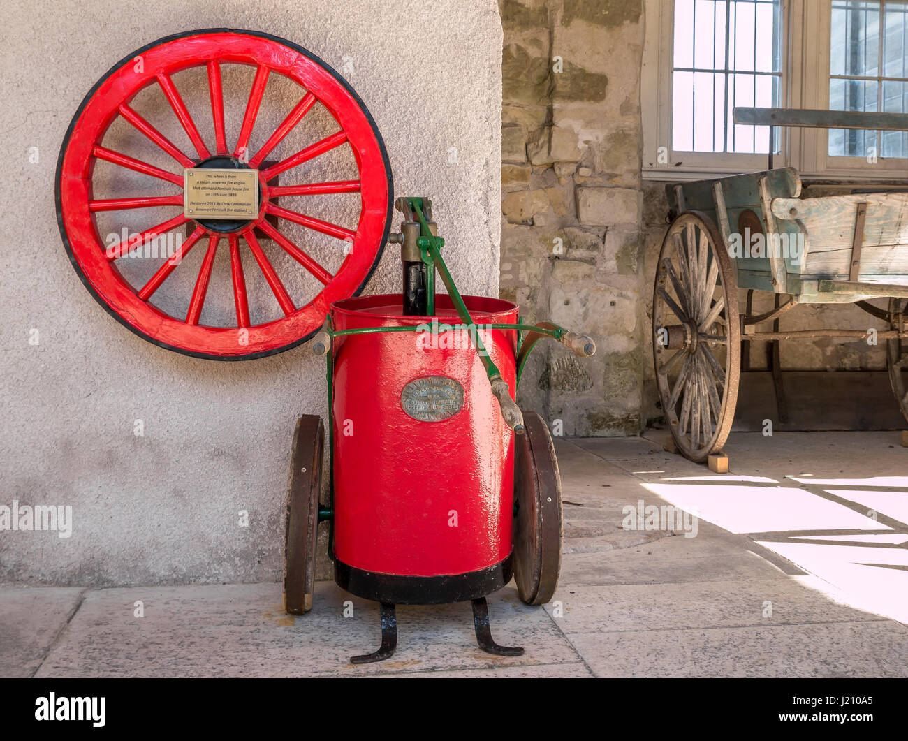 Old restored red wheel from steam powered fire engine and water pump on display, Penicuik House, Midlothian, Scotland, UK Stock Photo