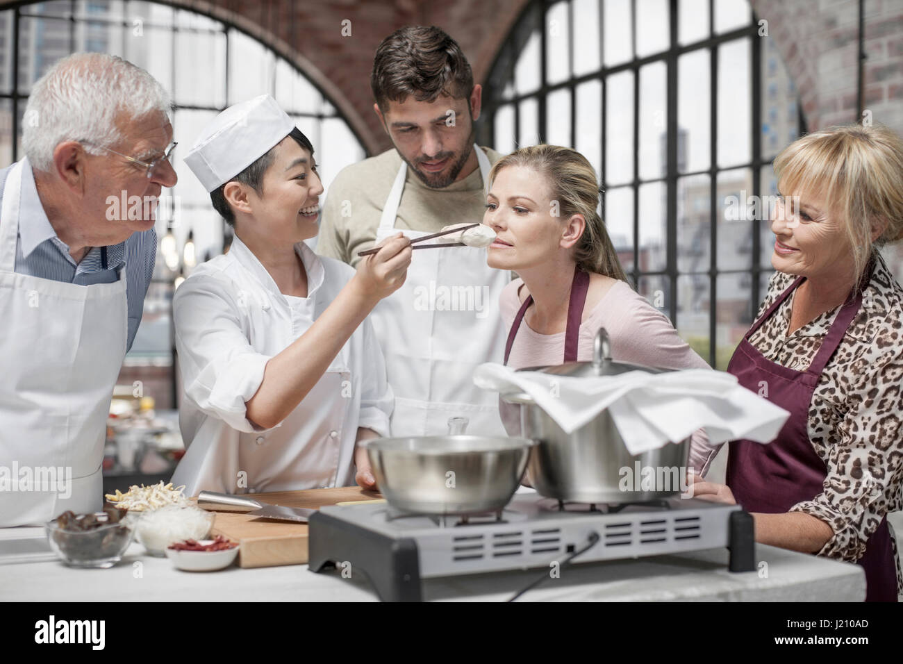 Woman smelling ingredient in cooking class Stock Photo - Alamy