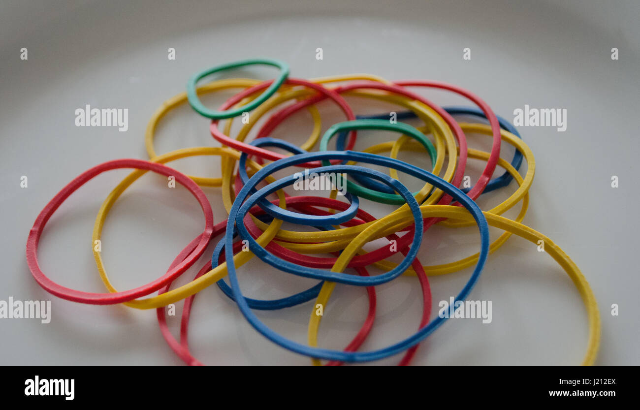 Multicolored rubber bands on white plate close up Stock Photo