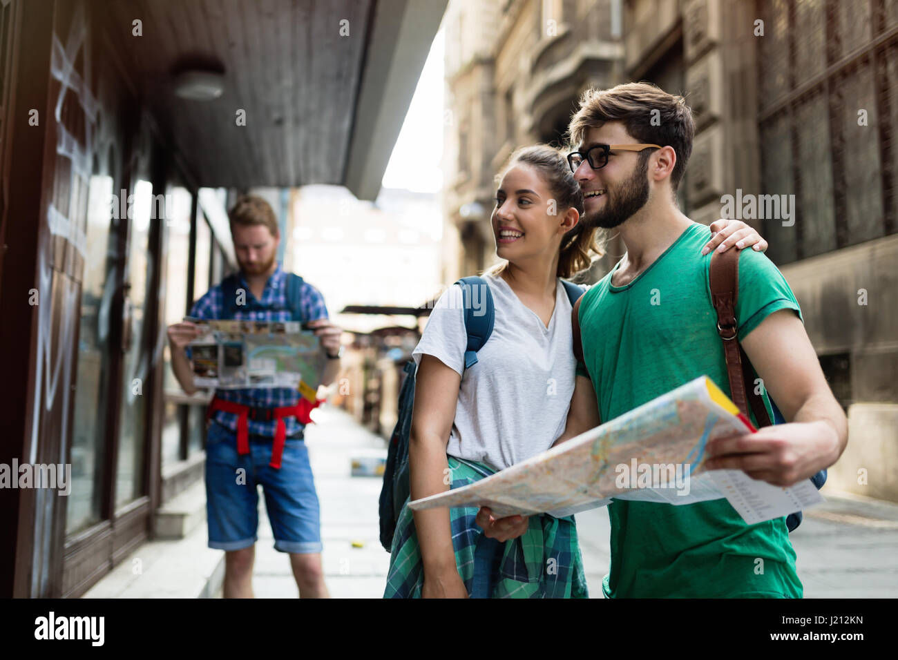 Young happy tourists holding map sightseeing in city Stock Photo