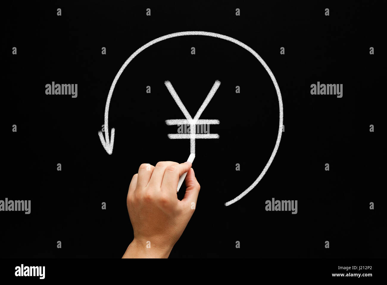 Hand sketching Japanese Yen or Chinese Yuan sign in arrow circle with white chalk on blackboard. Stock Photo