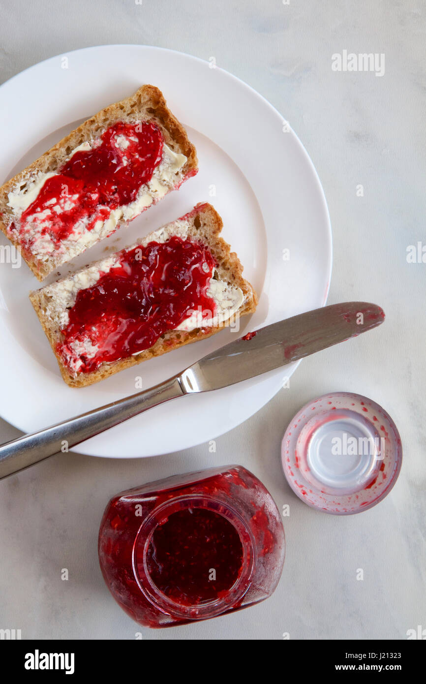 Raspberry jam on wholemeal toast Stock Photo Alamy