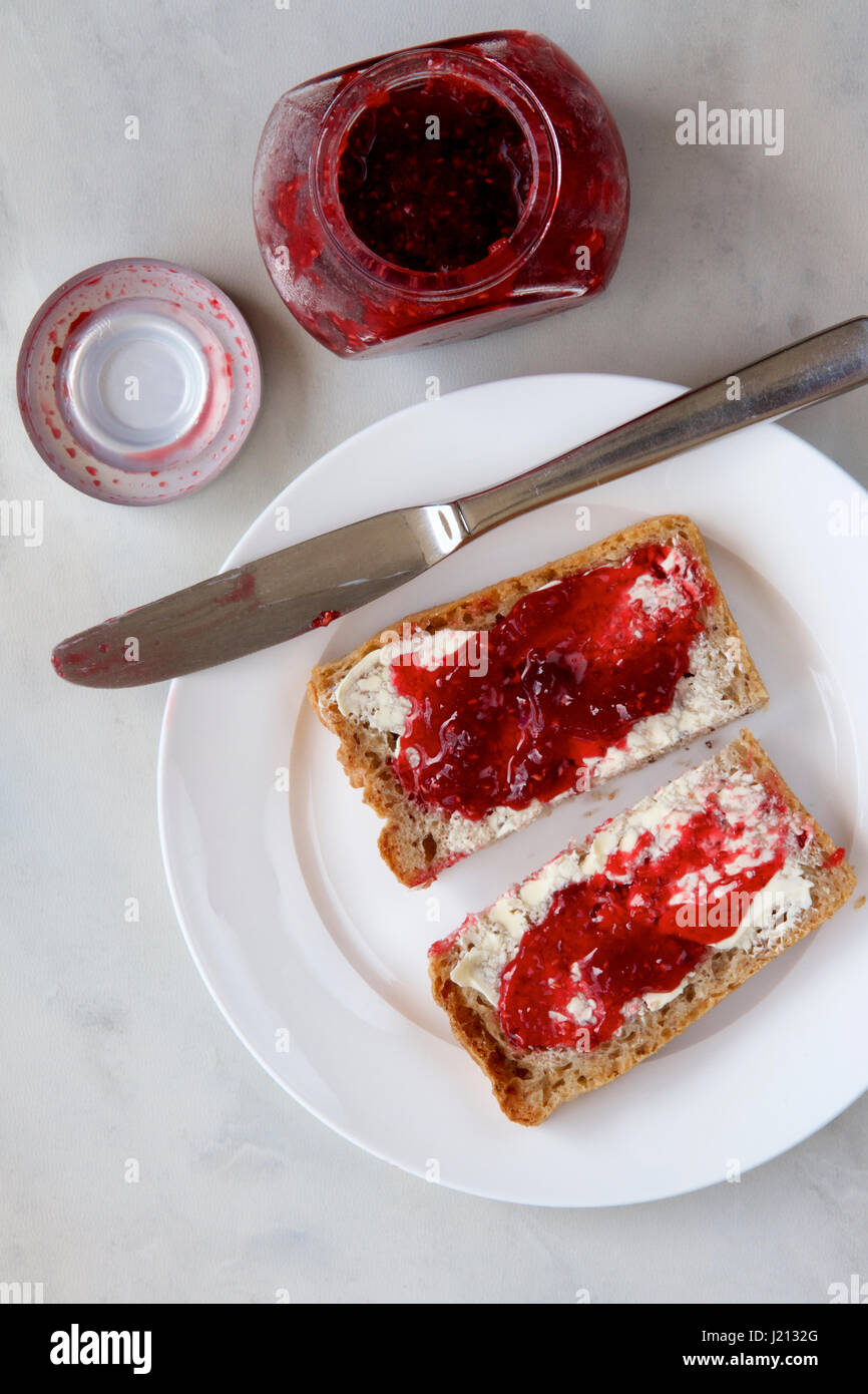 Raspberry jam on wholemeal toast Stock Photo Alamy