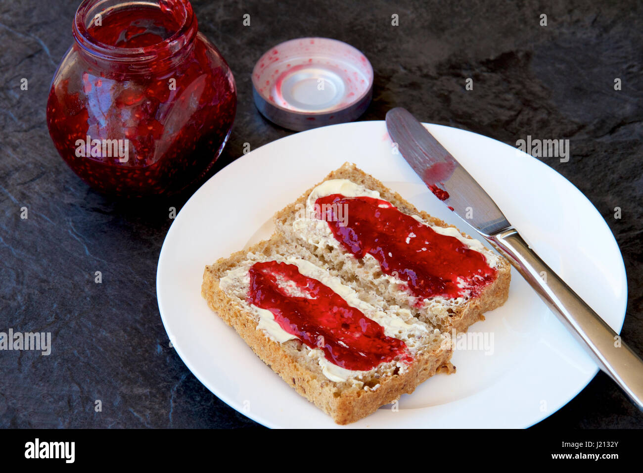 Raspberry jam on wholemeal toast Stock Photo Alamy