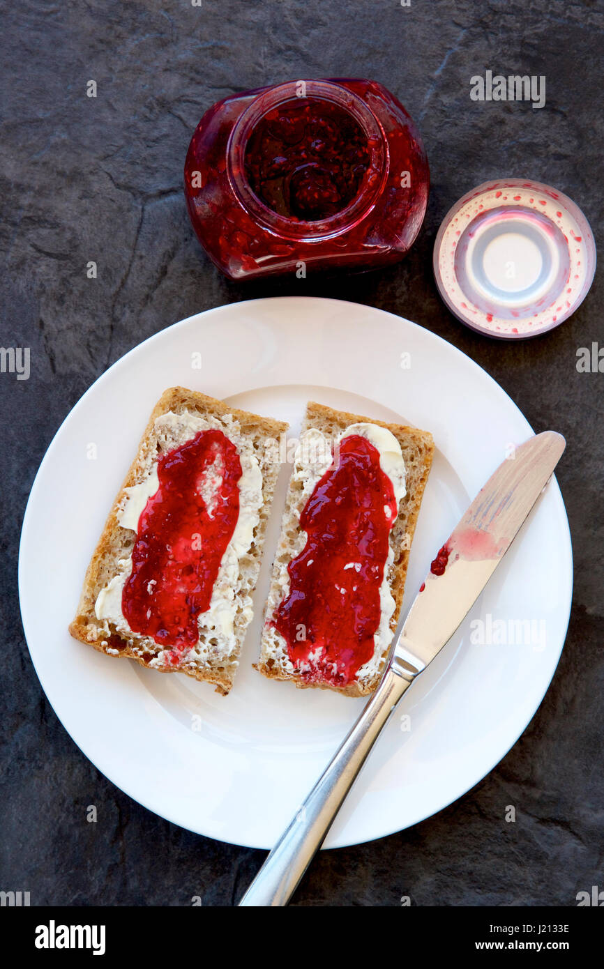 Raspberry jam on wholemeal toast Stock Photo Alamy