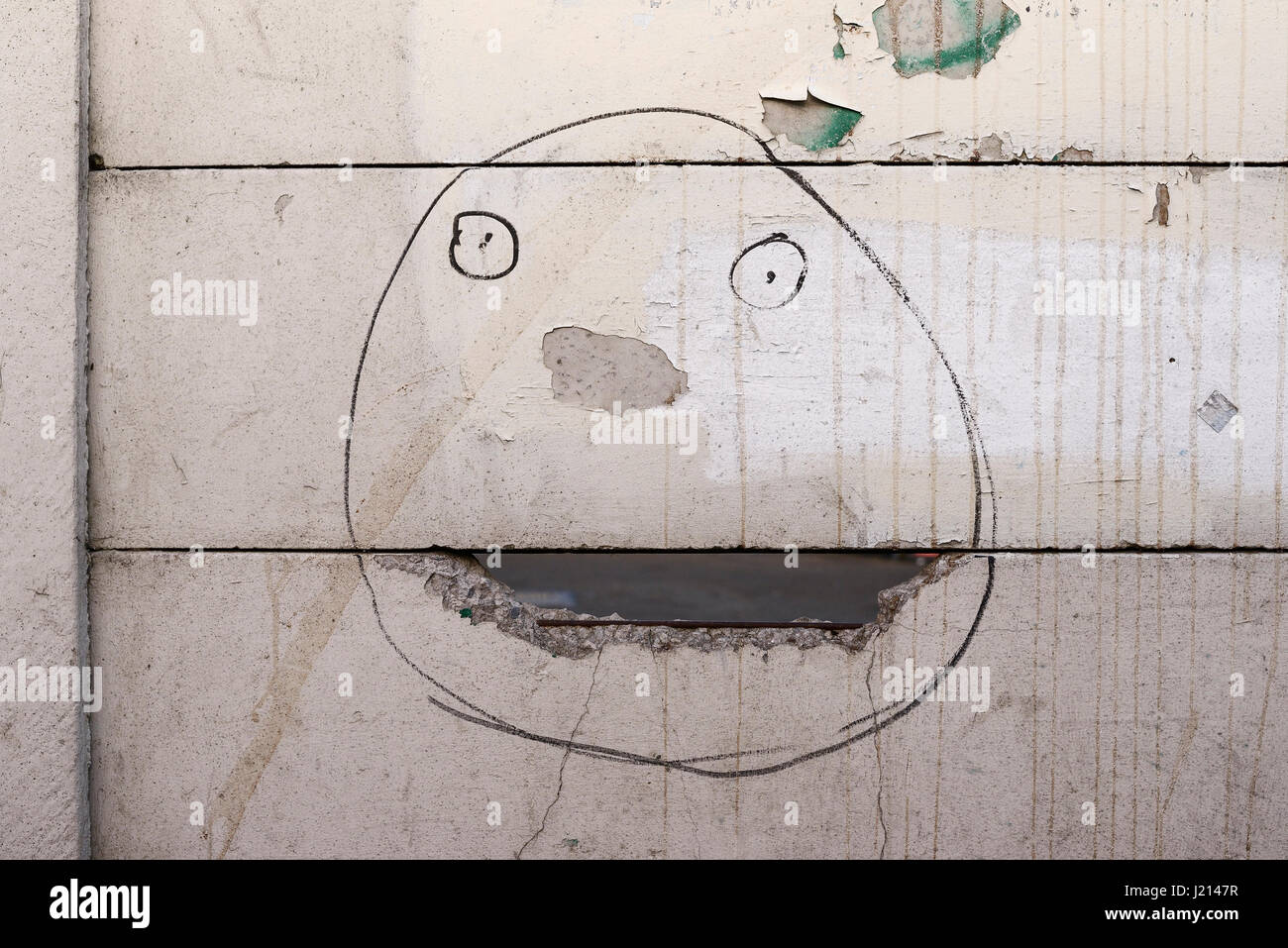 A face drawn on a broken fence Stock Photo