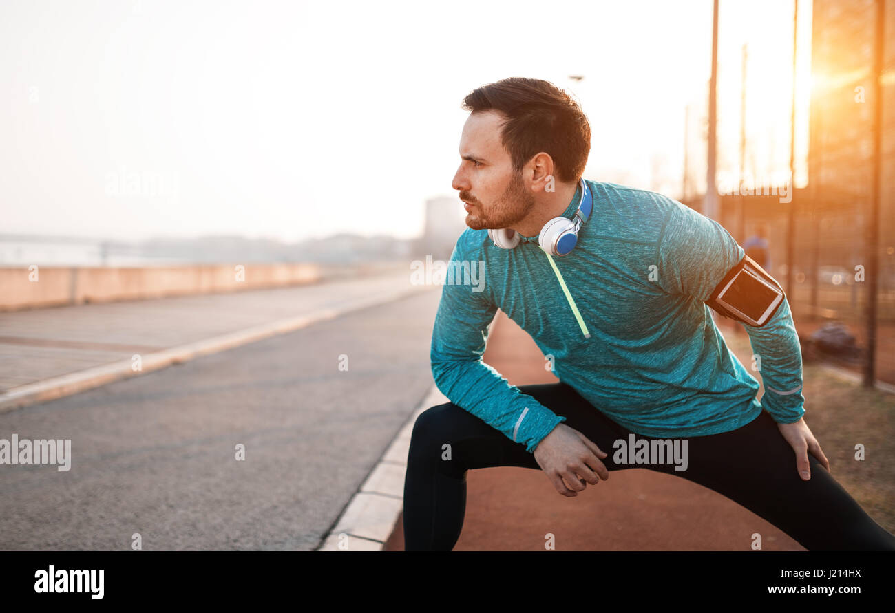 Handsome man stretching before exercising and running Stock Photo - Alamy