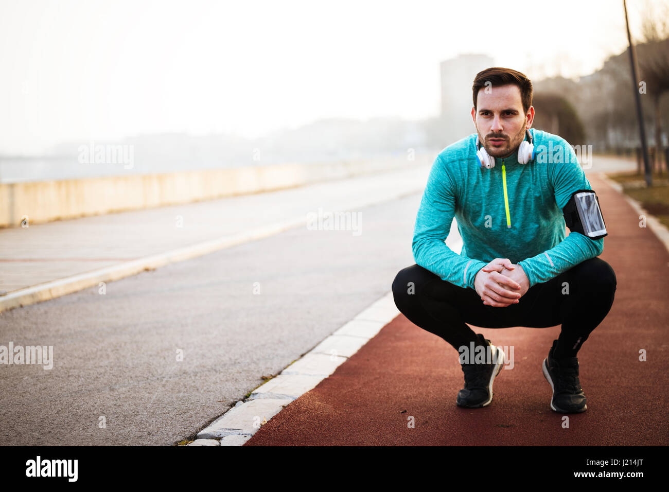 Sporty handsome man resting after jogging exercise Stock Photo