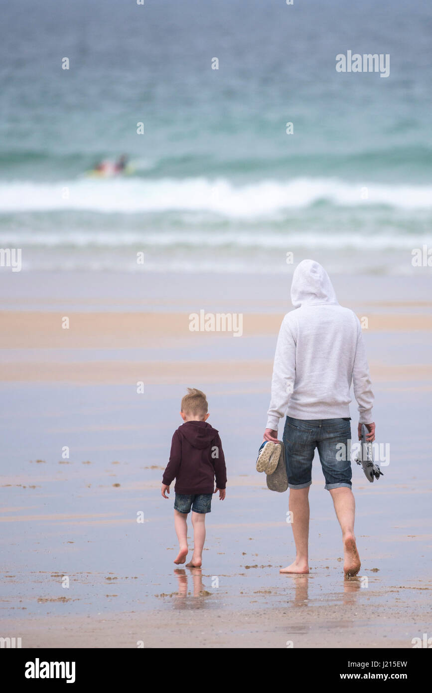 Fistral; Newquay; Seaside; Father and son; Walking on the beach; Sea; Tourism; Beach holiday; Vacation; Leisure time; Cornwall; Cornish; West country Stock Photo