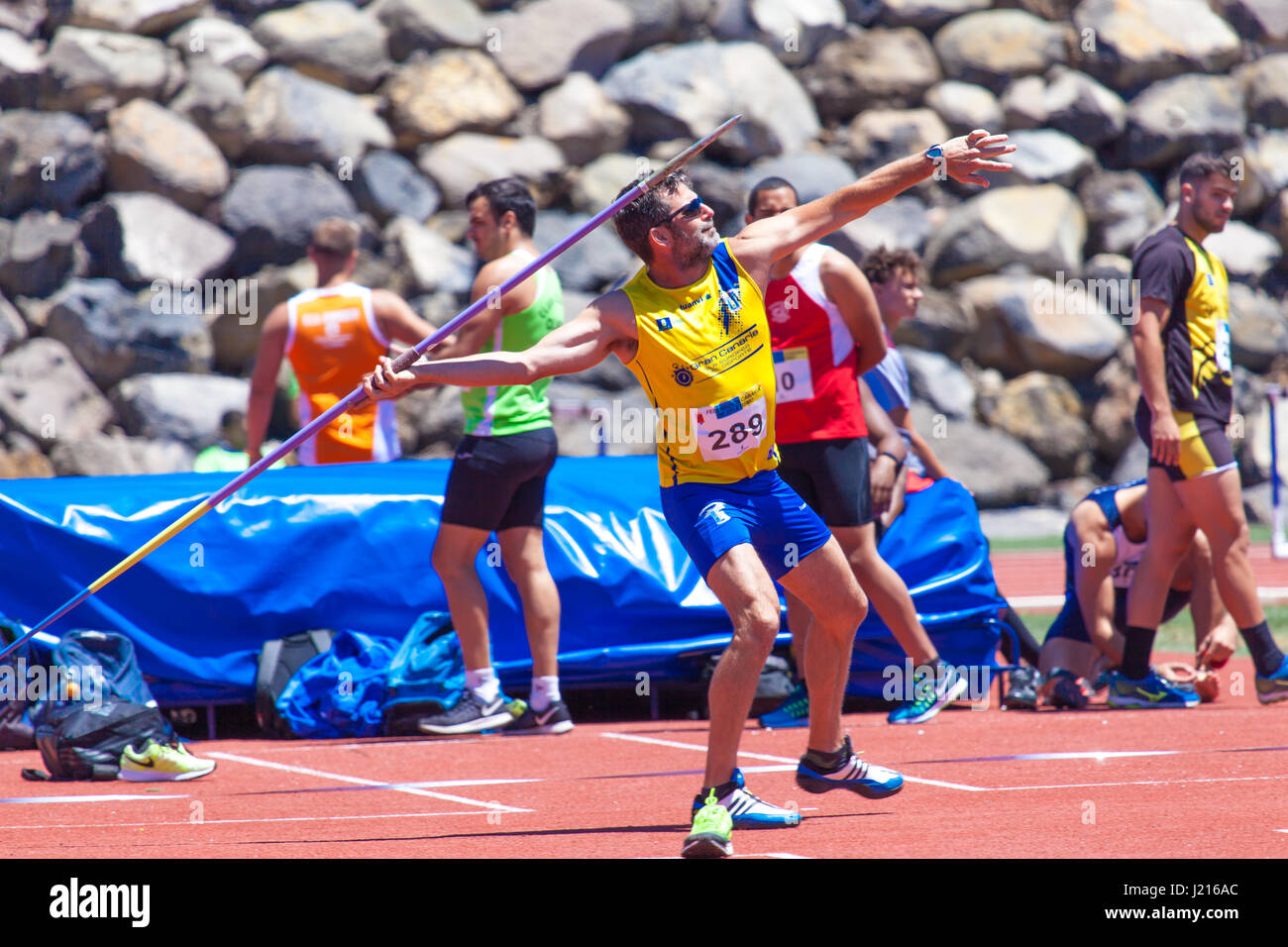 Young sportsman throwing javelin on a track and field competition Stock ...