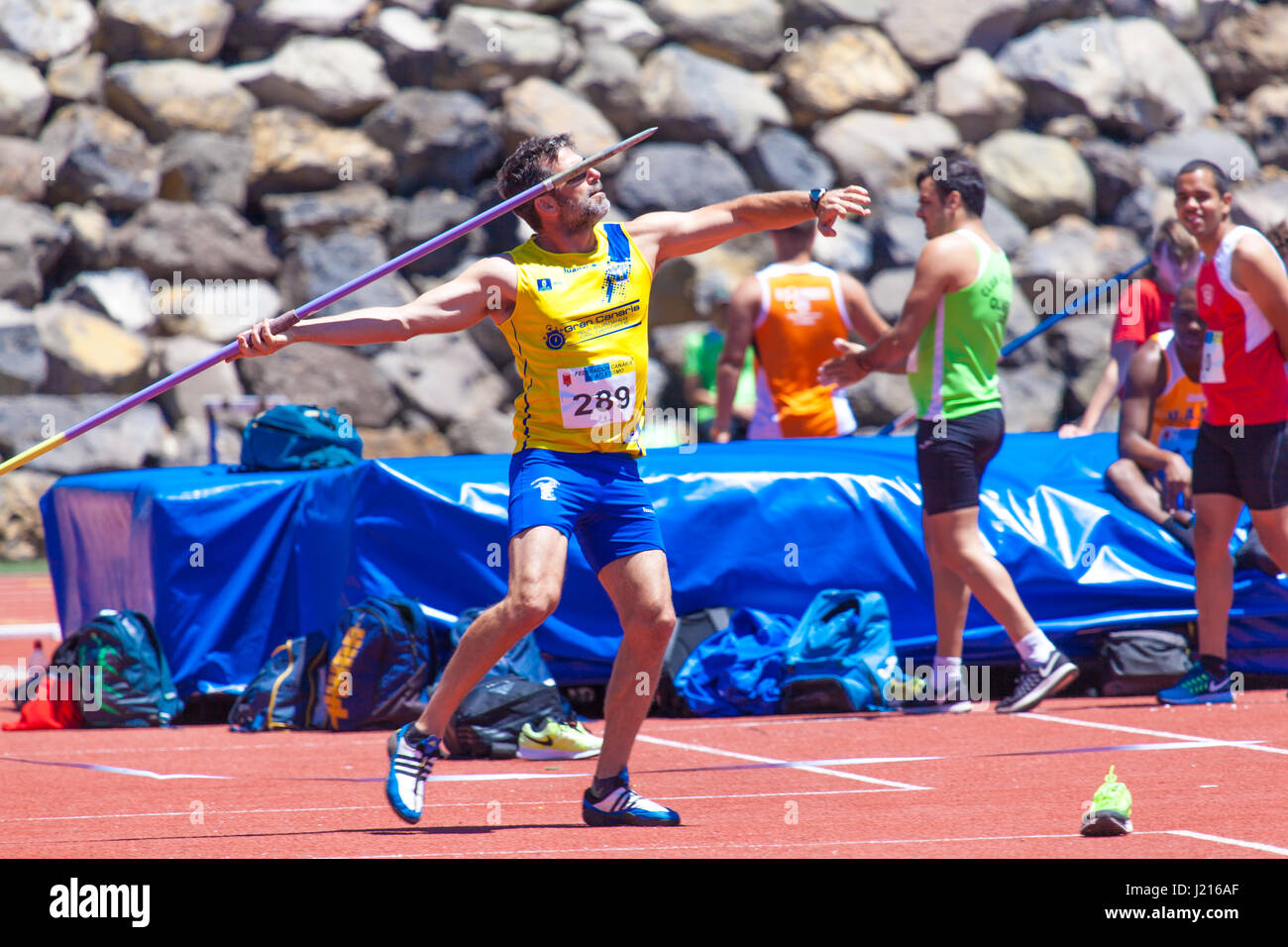 Young sportsman throwing javelin on a track and field competition Stock
