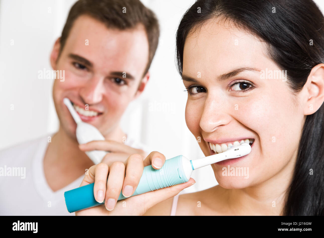 A Beautiful Interracial Couple In The Bathroom Brushing Teeth Stock