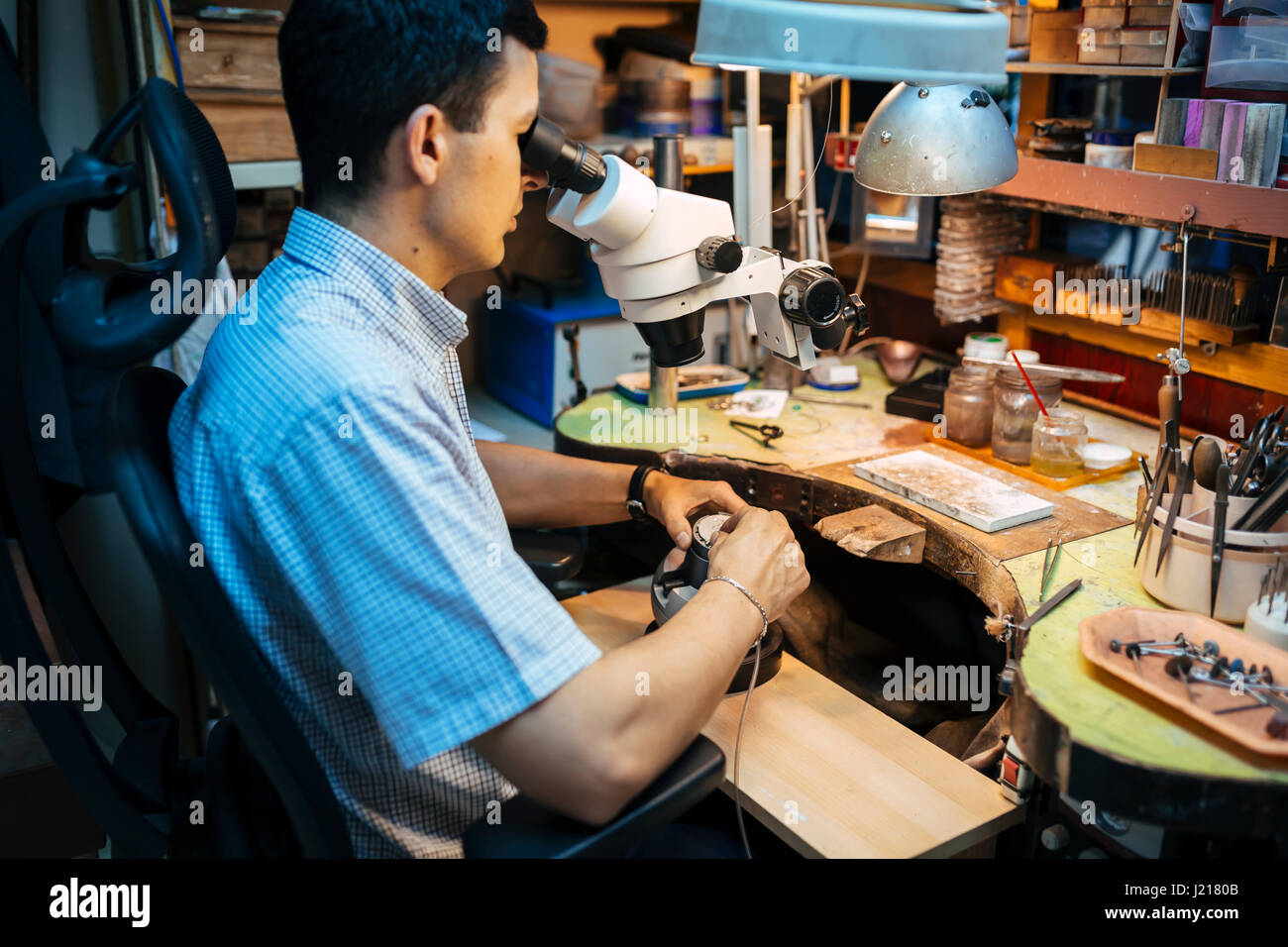 Precision work carried out by jeweler in workshop Stock Photo