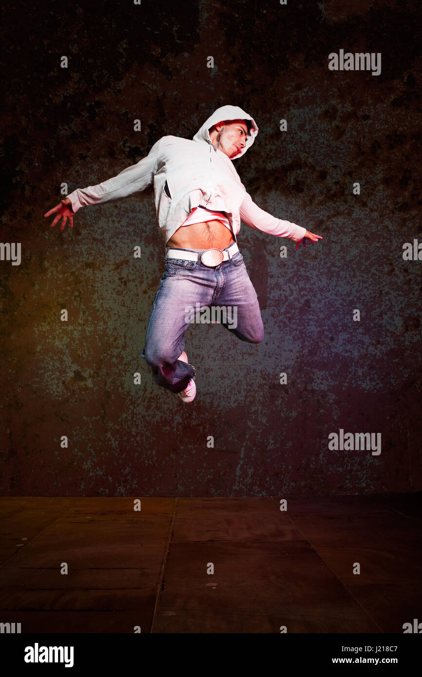 A shot of a hispanic male doing a hip-hop dance jumping in the air Stock Photo